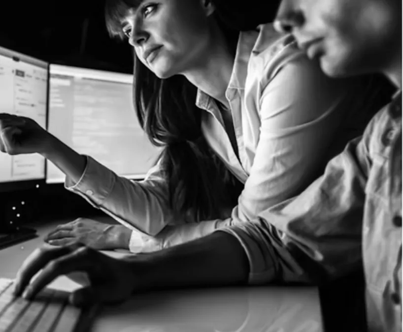 Investigators reviewing records together at computer monitors